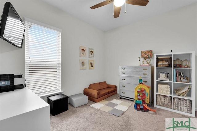 game room featuring light colored carpet and ceiling fan