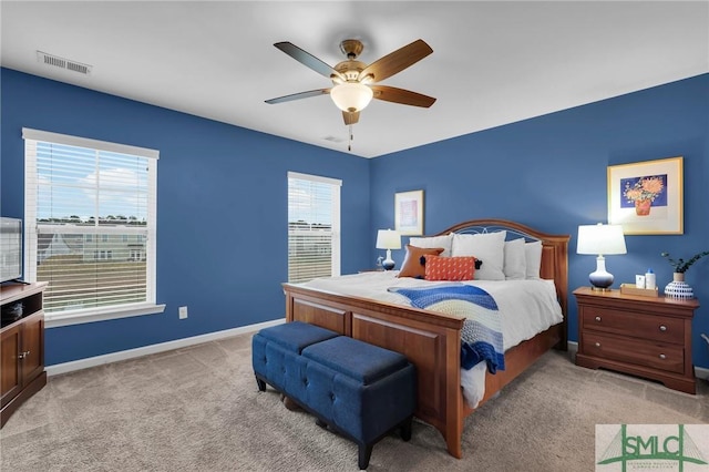 carpeted bedroom with multiple windows and ceiling fan