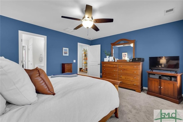 carpeted bedroom with ceiling fan and ensuite bath