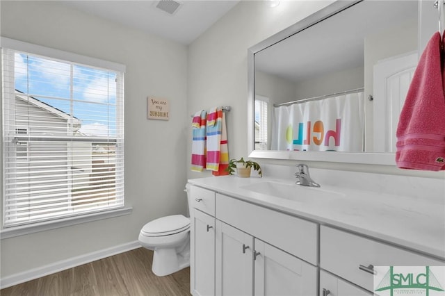 bathroom with vanity, toilet, and hardwood / wood-style floors