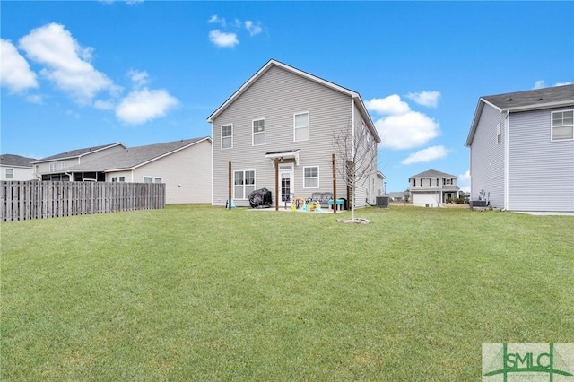 rear view of property featuring cooling unit and a yard