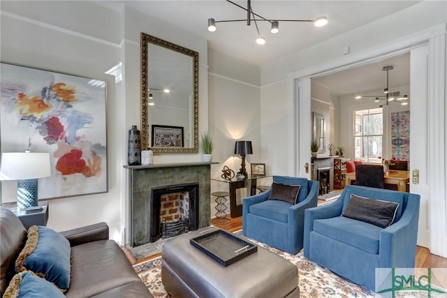 living room featuring a notable chandelier, hardwood / wood-style floors, and a fireplace