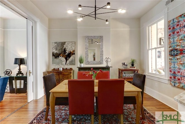 dining space featuring hardwood / wood-style flooring and an inviting chandelier