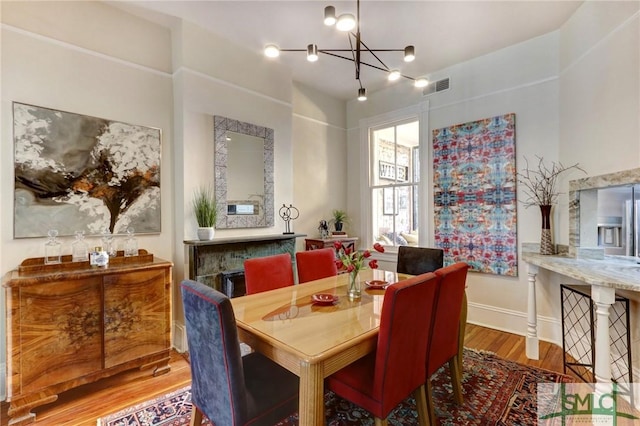 dining area featuring hardwood / wood-style flooring and an inviting chandelier