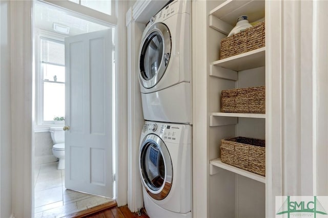 clothes washing area with stacked washer and clothes dryer