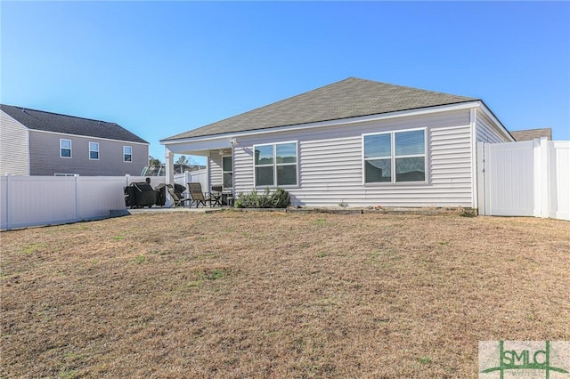 back of house with a patio area and a lawn