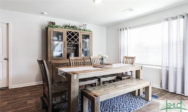 dining room featuring a healthy amount of sunlight and dark wood-type flooring