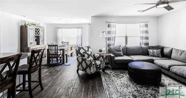 living room featuring ceiling fan and dark hardwood / wood-style flooring