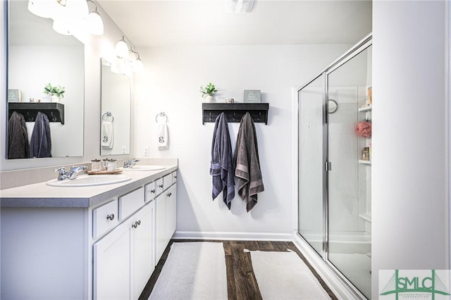 bathroom with vanity, a shower with shower door, and hardwood / wood-style floors