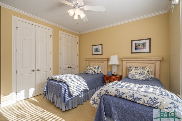 carpeted bedroom with two closets, ceiling fan, and ornamental molding