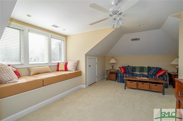 interior space featuring ceiling fan, light colored carpet, and lofted ceiling