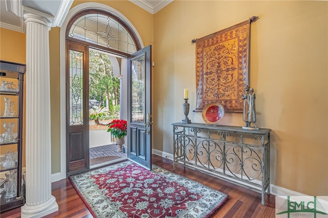 entrance foyer with dark hardwood / wood-style floors, ornamental molding, and ornate columns