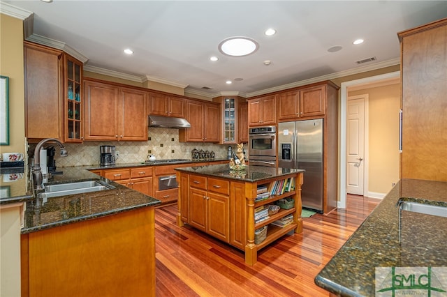 kitchen featuring sink, dark stone countertops, stainless steel appliances, and a kitchen island