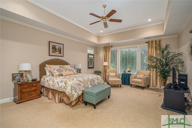 carpeted bedroom with ceiling fan, a raised ceiling, and crown molding