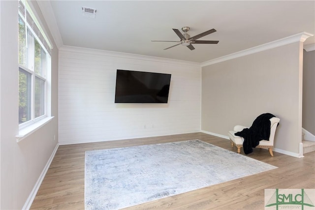 unfurnished room featuring light wood-type flooring, ceiling fan, a wealth of natural light, and crown molding