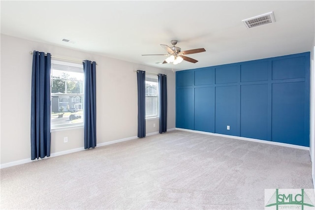 empty room featuring ceiling fan and light carpet