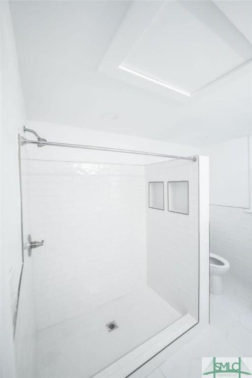 bathroom featuring a shower and toilet