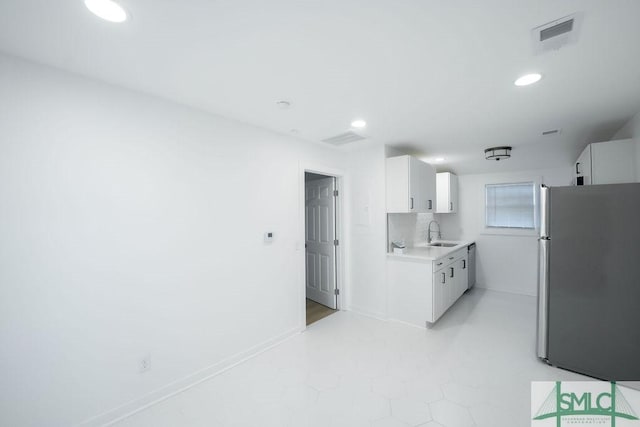 kitchen featuring sink, backsplash, white cabinets, and stainless steel appliances