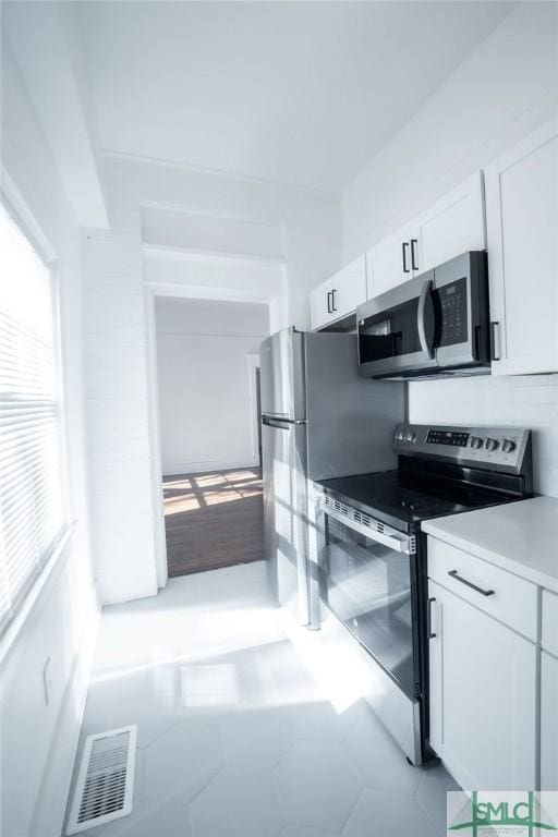 kitchen featuring white cabinetry, light tile patterned floors, and appliances with stainless steel finishes