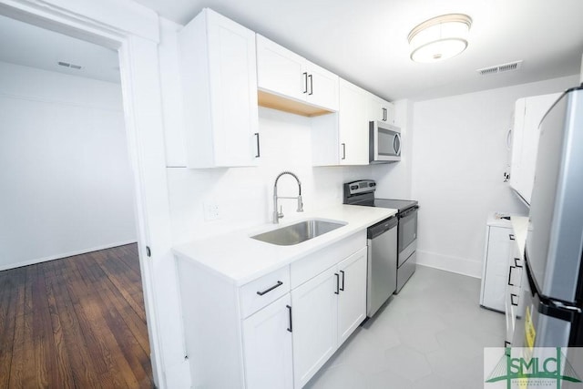 kitchen featuring sink, white cabinetry, and appliances with stainless steel finishes