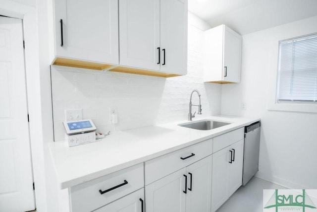 kitchen featuring sink, backsplash, white cabinets, and dishwasher