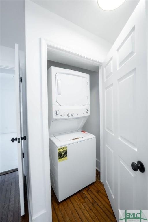 washroom featuring dark wood-type flooring and stacked washer and dryer