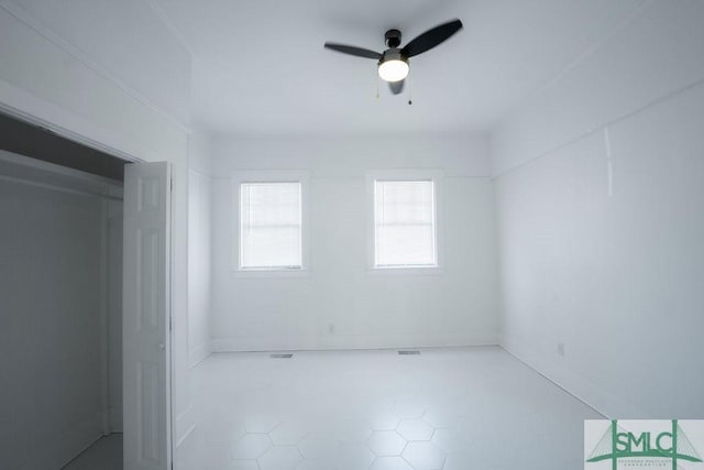 tiled spare room with ceiling fan