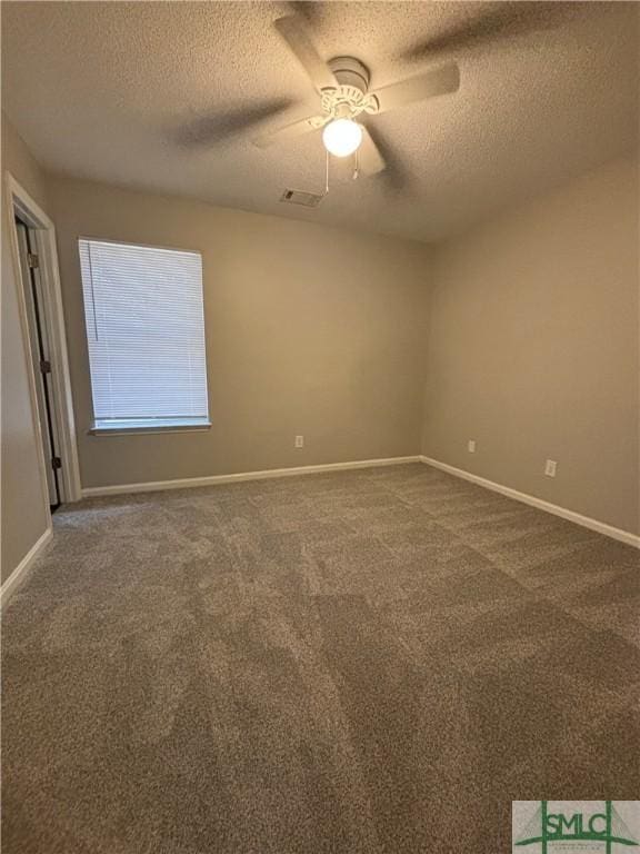 carpeted empty room with ceiling fan and a textured ceiling