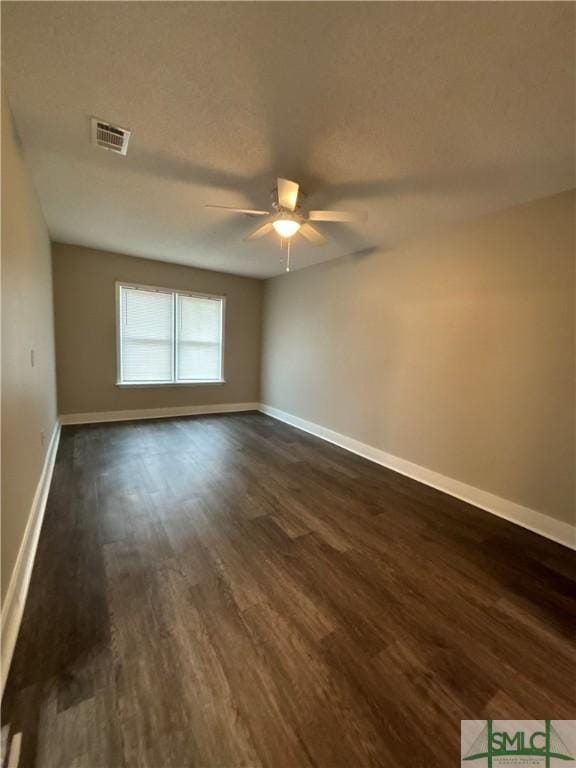 spare room with ceiling fan and dark hardwood / wood-style flooring