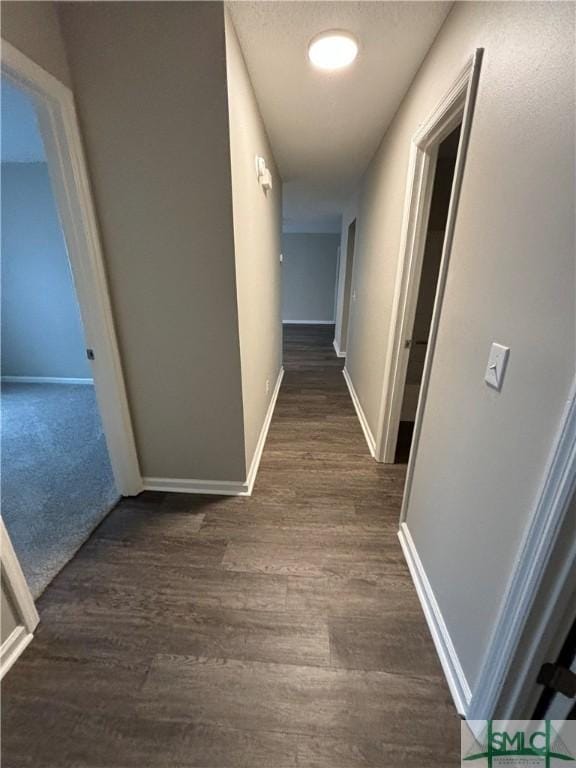 hall featuring a textured ceiling and dark hardwood / wood-style flooring