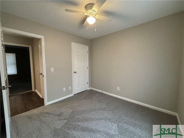 unfurnished bedroom featuring a textured ceiling, carpet floors, and ceiling fan