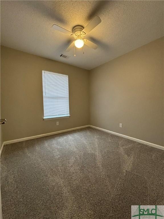 carpeted spare room featuring ceiling fan and a textured ceiling