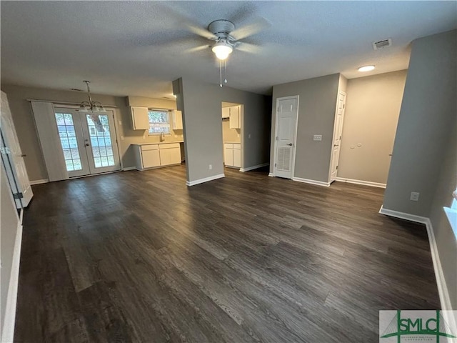 unfurnished living room with sink, dark hardwood / wood-style floors, and ceiling fan