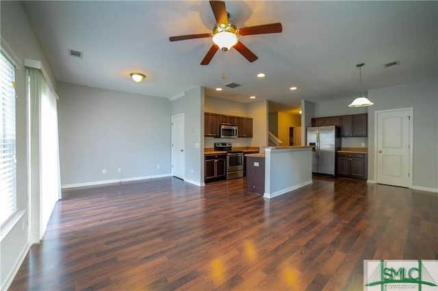 kitchen with plenty of natural light, hanging light fixtures, appliances with stainless steel finishes, and a kitchen island