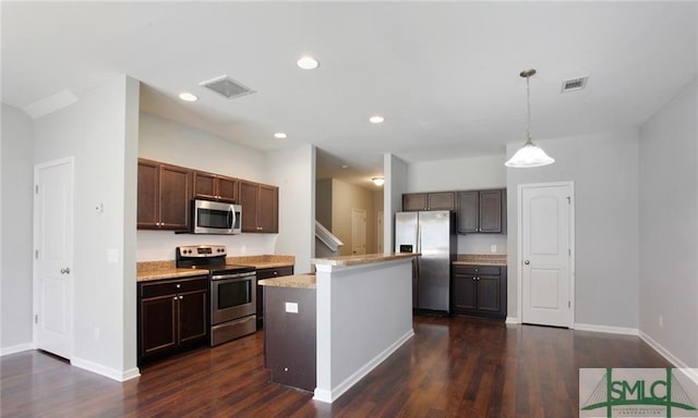 kitchen featuring hanging light fixtures, dark brown cabinets, a kitchen island, dark hardwood / wood-style flooring, and stainless steel appliances