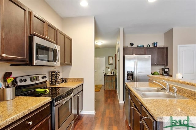 kitchen featuring dark wood-type flooring, sink, dark brown cabinetry, and stainless steel appliances