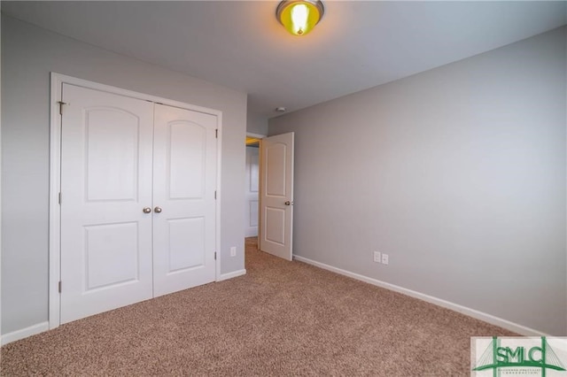 unfurnished bedroom with a closet and carpet flooring