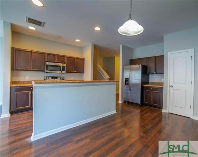 kitchen with dark brown cabinets, dark hardwood / wood-style flooring, decorative light fixtures, appliances with stainless steel finishes, and a kitchen island