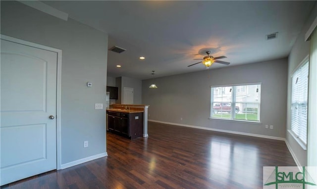 unfurnished living room featuring sink, dark wood-type flooring, and ceiling fan