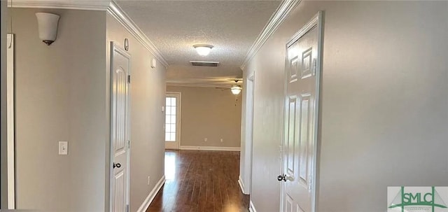 hallway featuring crown molding, a textured ceiling, and dark hardwood / wood-style floors