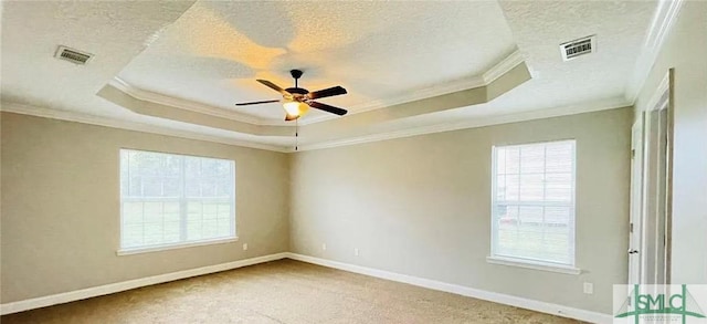 carpeted empty room featuring ceiling fan, crown molding, a textured ceiling, and a tray ceiling