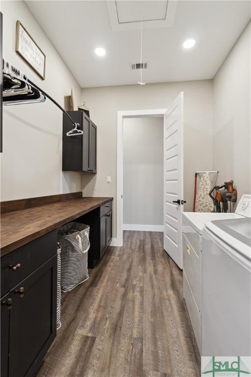 laundry room featuring visible vents, dark wood-type flooring, cabinet space, attic access, and washing machine and clothes dryer