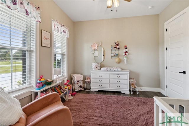 bedroom with dark wood finished floors, multiple windows, baseboards, and ceiling fan