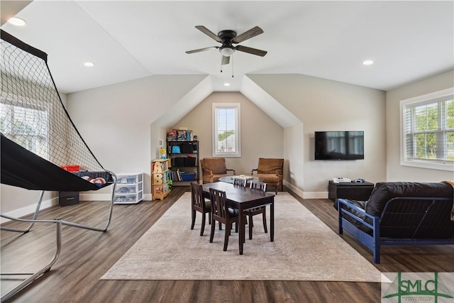 dining room featuring vaulted ceiling, a healthy amount of sunlight, baseboards, and wood finished floors