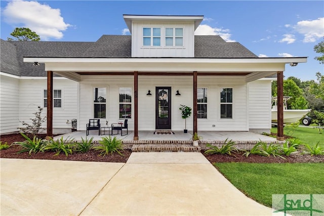 view of front of home with a porch, board and batten siding, and roof with shingles