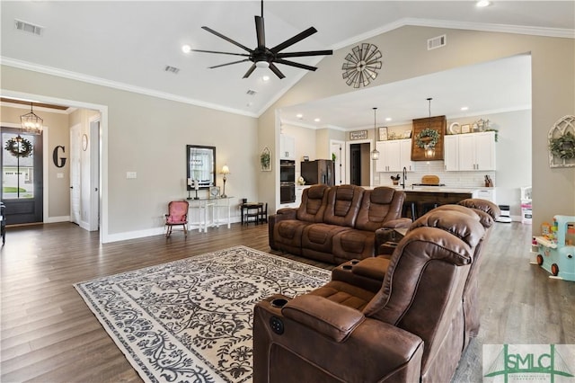 living room with sink, vaulted ceiling, crown molding, and dark hardwood / wood-style floors