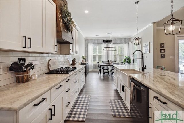 kitchen with crown molding, stainless steel gas cooktop, black dishwasher, white cabinetry, and a sink