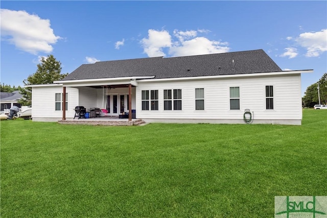 rear view of house with a lawn, a shingled roof, a patio, and ceiling fan