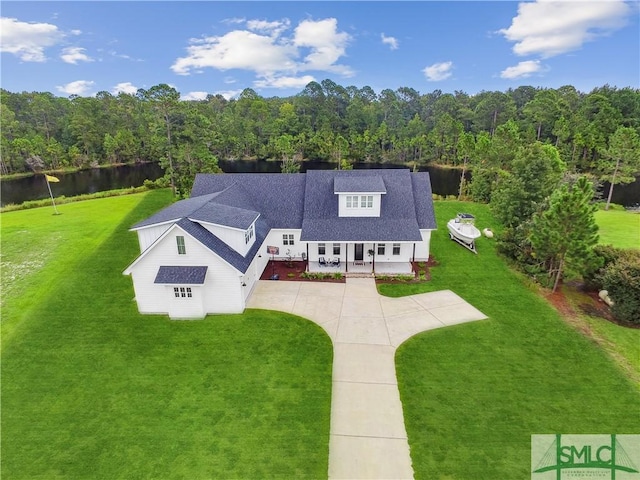 drone / aerial view featuring a wooded view and a water view