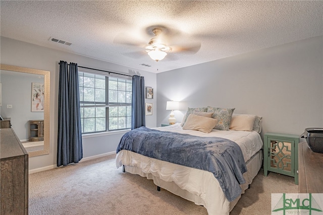 bedroom with light carpet, a textured ceiling, and ceiling fan